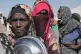 Sudanese women displaced from El-Fasher wait in line to receive food aid at the newly established El-Afadh camp in Al Dabbah, in Sudan's Northern State, November 16, 2025