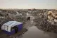 Palestinians walk among the ruins of destroyed buildings north of Gaza City, November 25, 2025