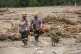 Rescuers lead a sniffer dog during the search for flood victims in Batang Toru, North Sumatra, Indonesia, Tuesday, Dec. 2, 2025