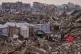 Palestinians stand next to a tent set up on the rubble of buildings destroyed by Israeli air and ground operations in the Sheikh Radwan neighborhood, in Gaza City, December 30, 2025