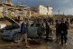 Palestinians looks at a destroyed car following an Israeli strike in Gaza City, December 13, 2025