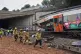 Police officers and firefighters inspect the damage after a commuter train derailed as a retaining wall collapsed onto the tracks in Gelida, near Barcelona, Spain, January 21, 2026