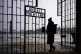 A women enters the Nazi concentration camp Sachsenhausen through gate with the phrase: 