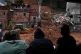 Residents watch firefighters and civil defense workers at the site where homes collapsed due to heavy rains and severe flooding in the Parque Burnier neighborhood of Juiz de Fora in Minas Gerais state, Brazil, February 24, 2026