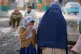 A young girl and a woman watch as rescue workers and officials inspect the site of a late-Monday air strike at a drug rehabilitation hospital in Kabul, Afghanistan, March 17, 2026