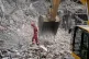 Iranian Red Crescent emergency workers use a bulldozer to clear rubble from a residential building that was hit in an earlier US-Israeli strike in Tehran, Iran, March 23, 2026