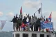 Activists wave Cuban and Palestinian flags from the vessel Maguro, arriving from Mexico with humanitarian aid as part of the ‘Nuestra America,’ or Our America convoy, in Havana Bay, Cuba, March 24, 2026