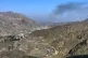 Smoke emits from the Afghan side as trucks are parked along a roadside following cross-border clashes between Pakistan and Afghan forces, near the Torkham border crossing point, Pakistan, February 28, 2026