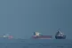 Oil tankers and cargo ships line up in the Strait of Hormuz as seen from Khor Fakkan, United Arab Emirates, March 11, 2026
