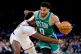 New York Knicks center Mitchell Robinson, left, defends Boston Celtics guard Jayson Tatum during the second half of an NBA basketball game Thursday, April 9, 2026, in New York