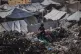 A child searches for reusable items at a landfill beside a tent camp housing displaced Palestinians in Deir al-Balah, central Gaza Strip, April 16, 2026