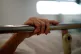 The hand of a patient grips the rail of a hospital bed in the X-ray department at The Royal Blackburn Teaching Hospital in East Lancashire, May 17, 2020