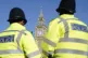 Elizabeth Tower, part of the Palace of Westminster, is seen between two Metropolitan Police officers in Parliament Square, London