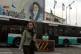 A woman crosses a street in front of a painting of the late Iranian revolutionary founder Ayatollah Khomeini in downtown Tehran, Iran, May 24, 2026