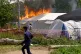 A security guard runs in front of an Ebola treatment center in flames in Rwampara, Congo, May 21, 2026