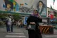 A woman crosses a street in front of a painting of the late Iranian revolutionary founder Ayatollah Khomeini and paramilitary Basij forces in downtown Tehran, Iran, May 24, 2026