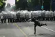 A man throws a cobblestone at riot police as clashes break out during a rally led by Serbia's protesting university students who are pushing for major political changes in the Balkan country run by President Aleksandar Vucic, in Belgrade, Serbia, May 23, 2026