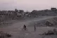    A man rides a bicycle beside the ruins of buildings destroyed by Israeli bombardments in Gaza City, Wednesday, June 10, 2026