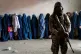 A Taliban fighter stands guard as women wait to receive food rations distributed by a humanitarian aid group, in Kabul, Afghanistan, May 23, 2023