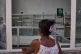 An image of Fidel Castro hangs on the wall of a state-run pharmacy where a woman asks for medication in Havana, Cuba, July 29, 2026