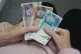 A pensioner holding bank notes