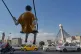 Vehicles drive past a statue of a swinging boy at a square in Tehran, Iran, August 10, 2026