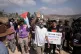 Activists march with food and water supplies toward the houses of three Palestinian families that have been besieged by Israeli settlers for six days, in the occupied West Bank village of Qusra, south of Nablus, August 14, 2026