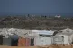 A shepherd tends to his flock as they graze on a rubbish dump near a camp for displaced Palestinians in Deir al-Balah, central Gaza Strip, August 14, 2026