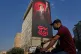 A man rides on his motorbike past a billboard with a message that reads in Farsi: 