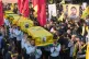 Hezbollah scouts carry the coffins of a Hezbollah member Ali al-Haj Hassan, his wife and his four children, who were killed on Saturday by an Israeli airstrike, during their funeral procession in the southern suburb of Beirut