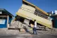 A man walks past a building that collapsed during an earthquake in Reo, East Nusa Tenggara province, Indonesia, August 17, 2026