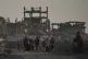 Palestinians walk amid the ruins of buildings destroyed by Israeli airstrikes during the war with Hamas, in Gaza City, August 17, 2026