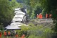 Rail workers and police officers investigate at the scene where a train with around 150 people on board derailed near Lewes railway station in East Sussex, August 14, 2026