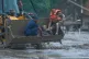 Rescuers use an earthmover to carry a victim of flash flooding to safety along the Trishuli River in Nepal's Nuwakot district, August 26, 2026