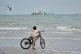 A boy stands with his bicycle overlooking commercial vessels anchored in the Strait of Hormuz off Bandar Abbas, Iran, September 7, 2026