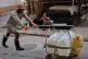 A man pushes a cart filled with water containers while another man rests on a sofa on a street in Havana, Cuba, August 27, 2026