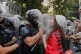 A woman draped in an Albanian flag clashes with police officers during ongoing demonstrations in Tirana, Albania, September 8, 2026