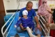 A man sits with a child in a hospital who was injured in a strike on a home where a wedding was taking place in Kuhestak, southern Iran, September 2, 2026