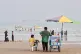 WAR AND PEACE: A juice seller among beachgoers with ships anchored in the Strait of Hormuz off Bandar Abbas, Iran, on August 31 2026