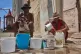 Oscar Joaquín López, left, and Wilfredo Cisneros Duarte collect water from a street pipe in Havana, Cuba, September 7, 2026