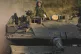 WAR SPIRAL: Israeli soldiers drive a tank to a staging area