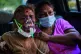 An Indian woman breathes using an oxygen mask as she waits f