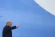 President Donald Trump waves from the top of the steps of Ai