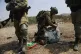 An Israeli soldier leans on the neck of a Palestinian man du