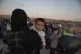 A woman holds her baby as refugees and migrants disembark at