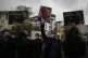 People hold posters with caricatures of France's President E