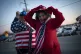 Trump supporters adjust their hats as they walk towards a sh