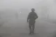 Indian paramilitary soldiers patrol on a road engulfed with 