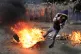 A protester covers himself from flames during a protest agai