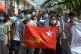 Anti-coup protesters hold the flag of the National League fo